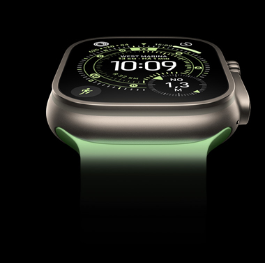 Close de um Apple Watch Ultra 3 com caixa natural de titanio sobre um fundo preto. A tela mostra a hora e outros dados dinamicos.