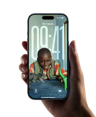 Uma m?o segura um iPhone que mostra o novo design em Liquid Glass, que faz as horas se adaptarem dinamicamente à imagem da Tela Bloqueada