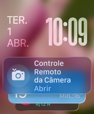 O widget Controle Remoto da Camera aparece na parte inferior da tela, números das horas translúcidos no canto superior direito e data no canto superior esquerdo..