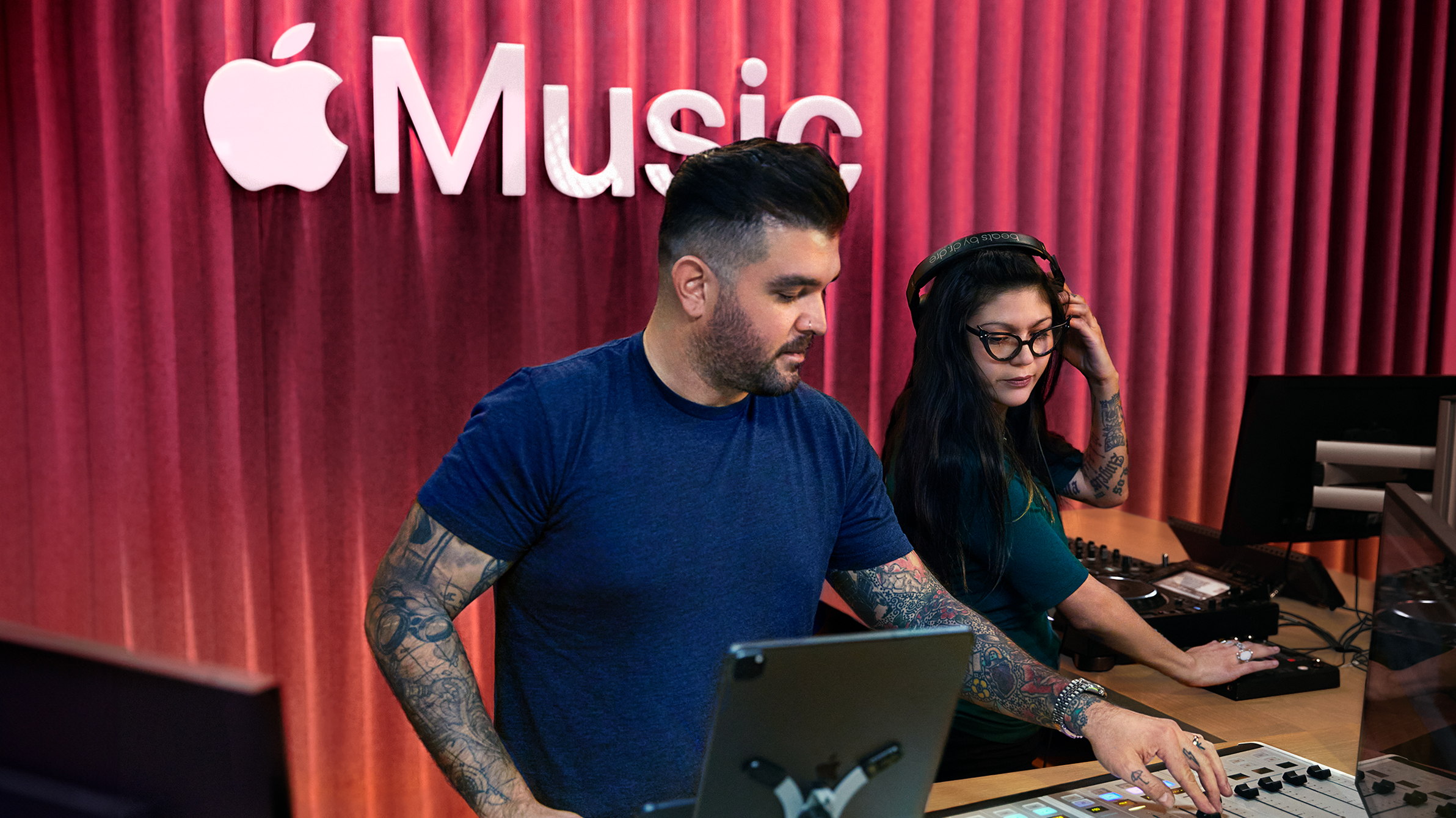Deux collègues Apple utilisent une table de mixage dans un studio Apple?Music.