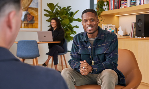 Justin est assis dans le salon d’un bureau et discute avec un collègue?Apple.