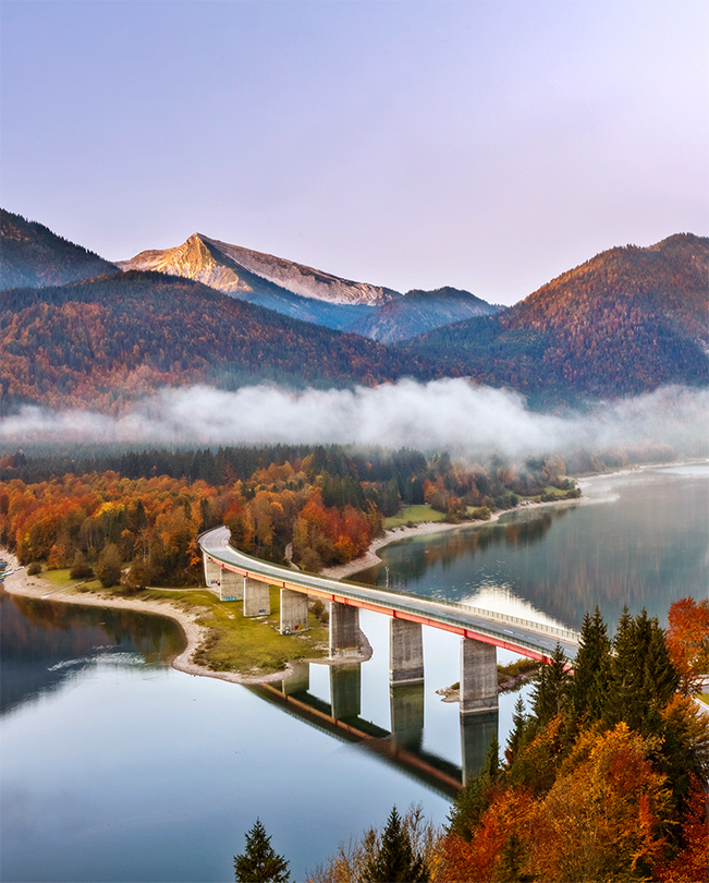 Most p?es jezero s?horami v?pozadí.