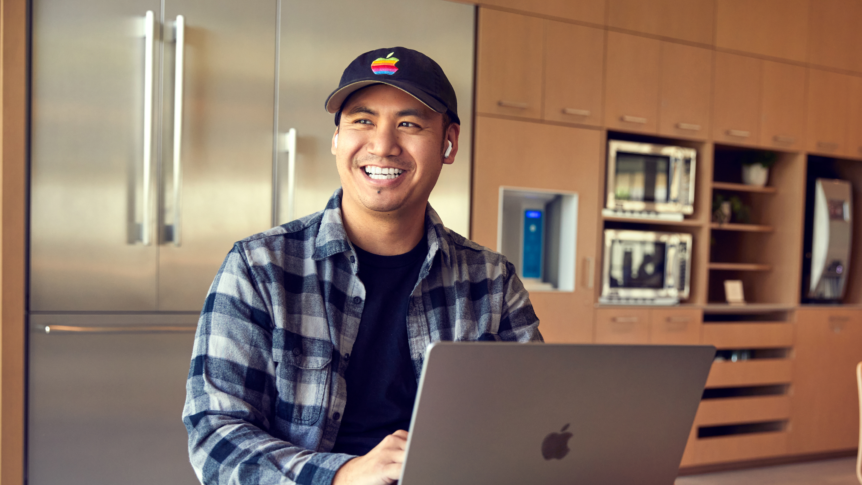 Zaměstnanec Apple San Diego se usmívá p?i práci na notebooku.