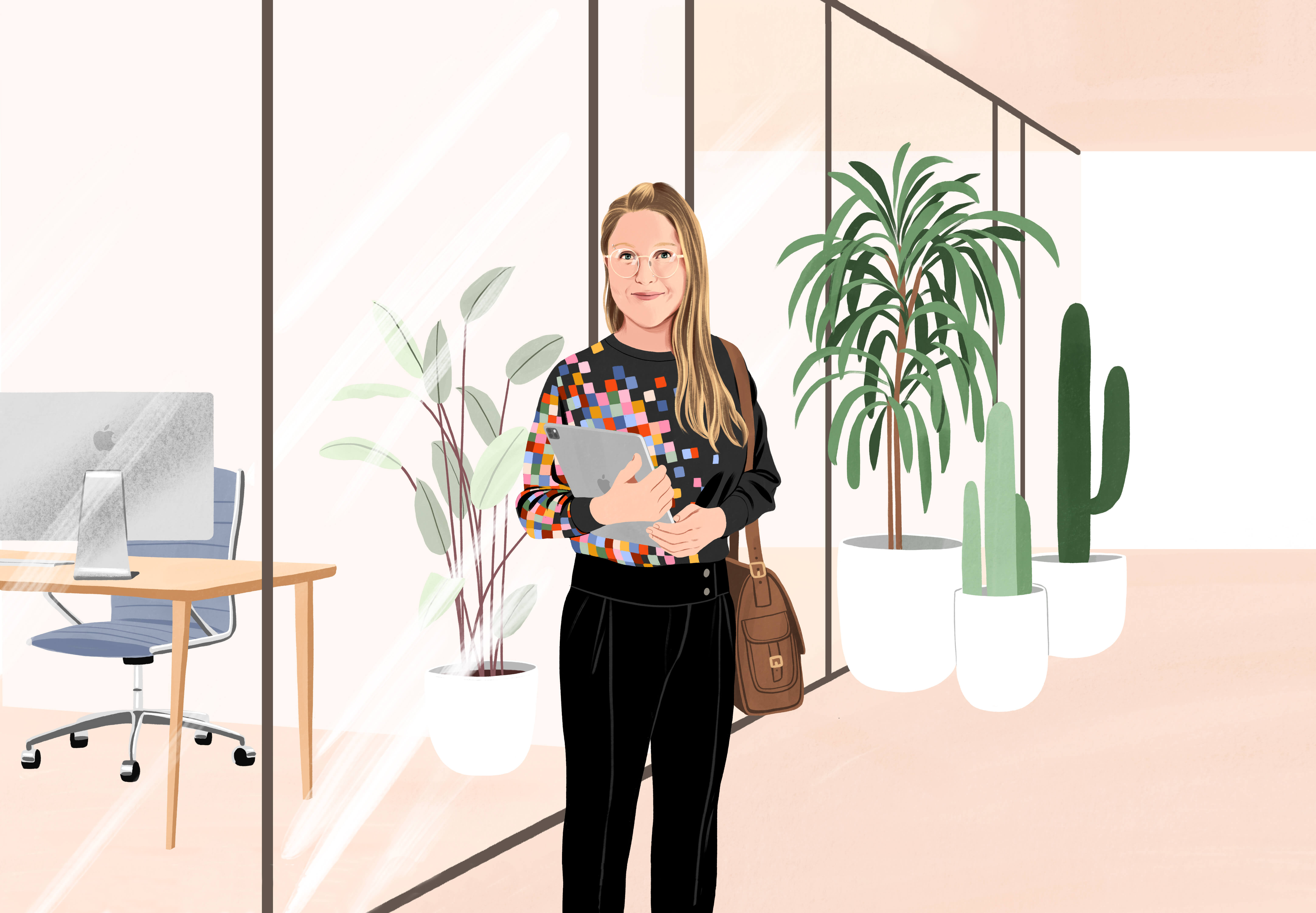 Manuela debout et souriant dans le hall d’un bureau. Elle a un sac à l’épaule et tient un iPad. Elle porte un pantalon et un pull noirs avec un motif de pixels colorés sur un c?té.