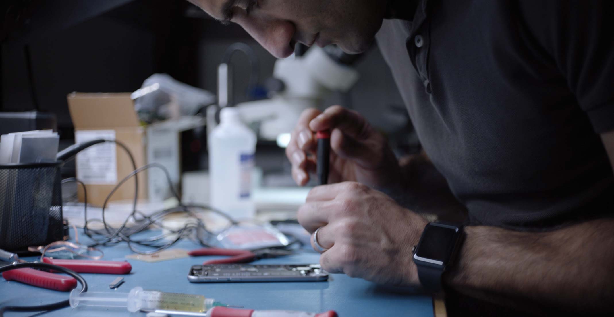 Ehsan, mened?er ds. projektów in?ynierskich w zespole Sensing Product Design firmy Apple, pracuje nad iPhonem w pracowni in?ynierskiej.