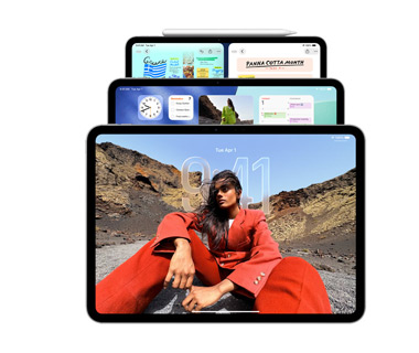 Drei iPad Modelle im Querformat, die sich überlagern, der Apple Pencil ist magnetisch an der Oberseite des hinteren Modells befestigt, auf dem vorderen Bildschirm ist ein Sperrbildschirm mit Liquid Glass Effekt zu sehen, der mittlere Bildschirm zeigt den Homescreen mit Widgets. Das hinterste iPad zeigt zwei Apps nebeneinander als Beispiel für die Fensteranordnung