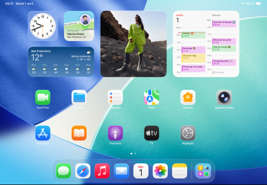 Trois modèles d’iPad, orientation paysage, avec le modèle au centre devant les deux autres, un Apple Pencil fixé de fa?on magnétique à son sommet, l’écran central montre l’écran d’accueil où s’affichent des ic?nes d’app colorées à effet Liquid Glass, l’écran de gauche montre l’app Aper?u, l’écran de droite montre l’écran d’accueil avec des fichiers qui sortent du Dock