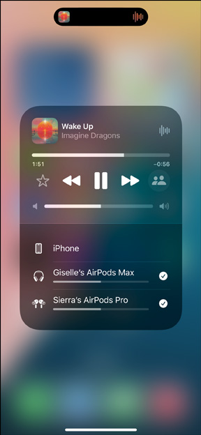 裝有 AirPods Pro 的充電盒旁邊有一部 iPhone，iPhone 連接了兩組 AirPods，每組都有獨(dú)立的音量控制。