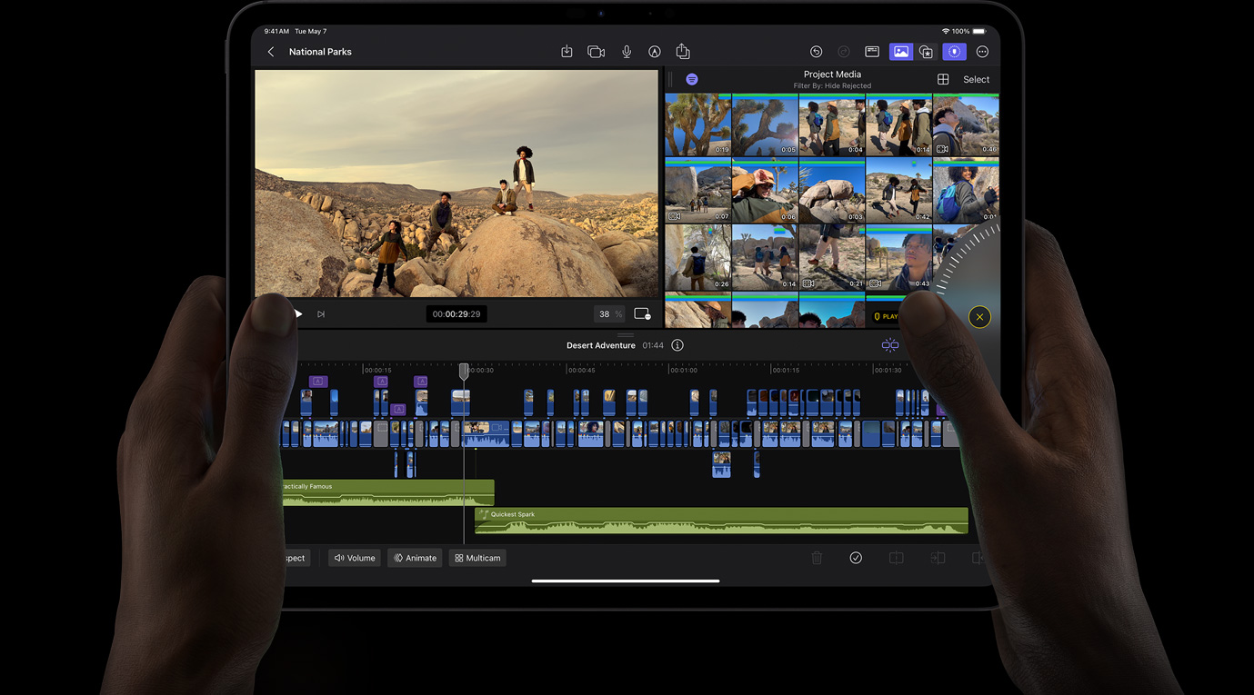 雙手拿著 iPad Pro，在 iPad 版 Final Cut Pro 上轉(zhuǎn)動 Jog Wheel 查看影片片段。