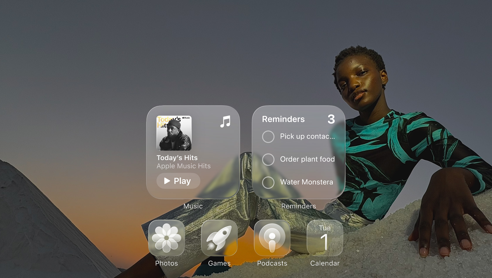 Liquid Glass képerny? az Apple Music, az Emlékeztet?k, a Fotók, a Játékok, a Podcastok és a FaceTime app áttetsz? ikonjaival, amelyeken átsz?r?dik a háttérkép