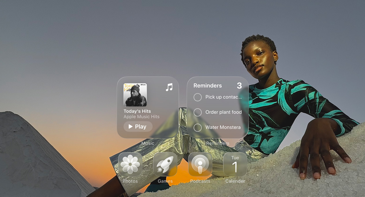 Liquid Glass képerny? az Apple Music, az Emlékeztet?k, a Fotók, a Játékok, a Podcastok és a Naptár app áttetsz? ikonjaival, amelyeken átsz?r?dik a háttérkép