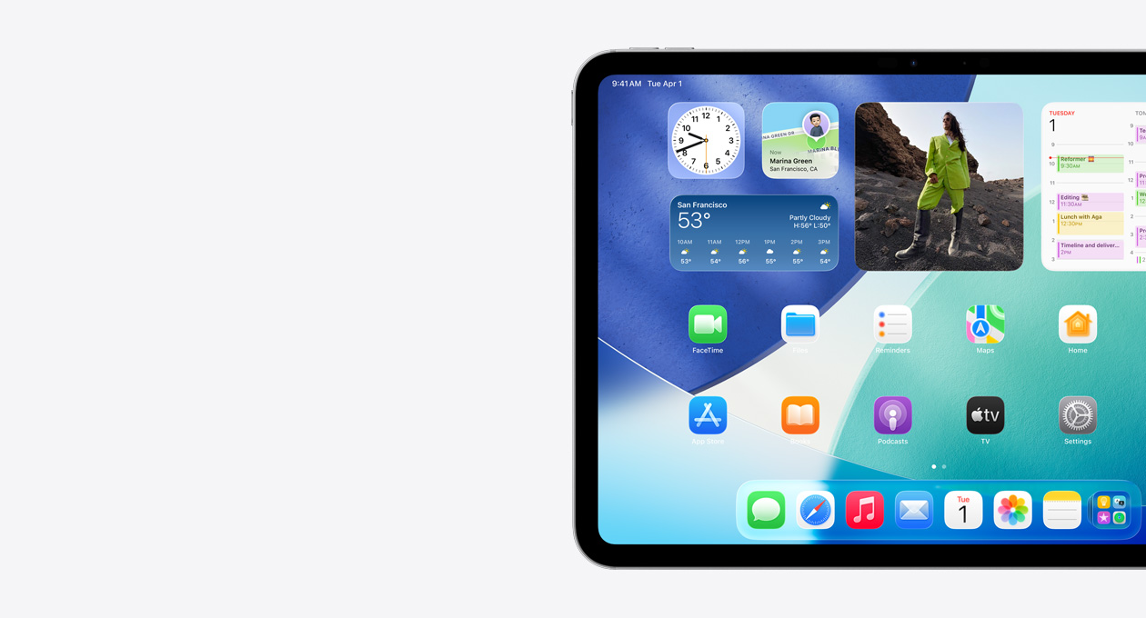 橫向きのiPad。畫(huà)面の左側(cè)のみが見(jiàn)えている。Liquid Glassのエフェクトを持つ半透明の時(shí)計(jì)などを含むウィジェットスタック、「探す」アプリ、天気ウィジェット、2列に並んだ小さなアプリ、Dockがホーム畫(huà)面に表示されている