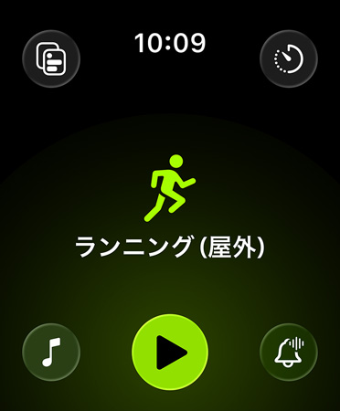 ワークアウトアプリの新しいレイアウト。ブラックの背景の四隅に配置されたグリーンのボタンから、アラート、音楽、様々な體験、カスタムワークアウト、測定値にアクセスできる。中央にはグリーンのランナーのアイコンがあり、その下にはホワイトの「ランニング（屋外）」というテキスト、さらに下にはグリーンの再生ボタンがある