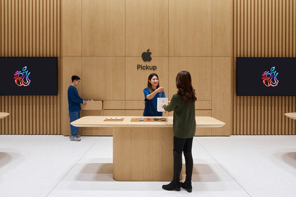 Khách hàng ?ang trò chuy?n v?i nhan viên t?i khu v?c Apple Pickup riêng bi?t c?a c?a hàng. 