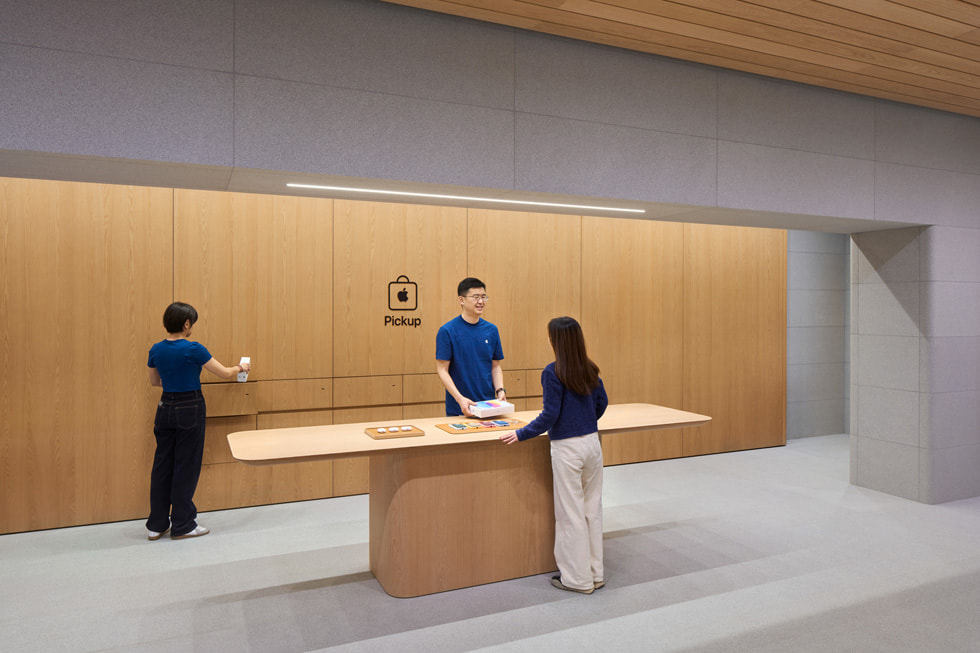 Hình ?nh nhan viên ?ang h? tr? cho khách hàng t?i qu?y Apple Pickup bên trong c?a hàng.