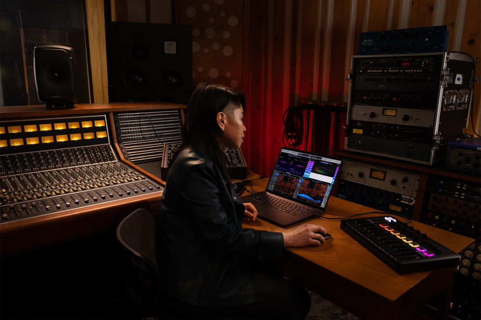 Logic Pro kullanc?s? müzik stüdyosunda MacBook Pro’da ?al???rken g?steriliyor.