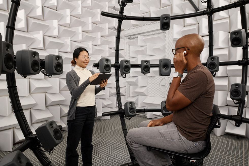 Un miembro del equipo se ubica de pie frente a un participante sentado en el Fantasia Lab, dentro del Audio Lab de Apple.