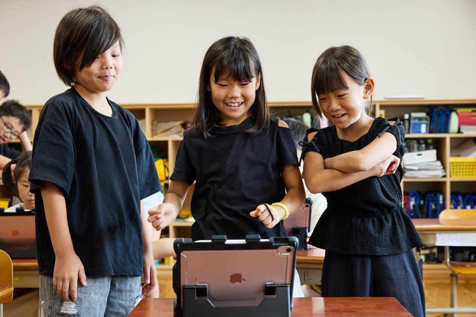 京都の小學(xué)校の教室で、iPadを見(jiàn)ている3人の子ども。