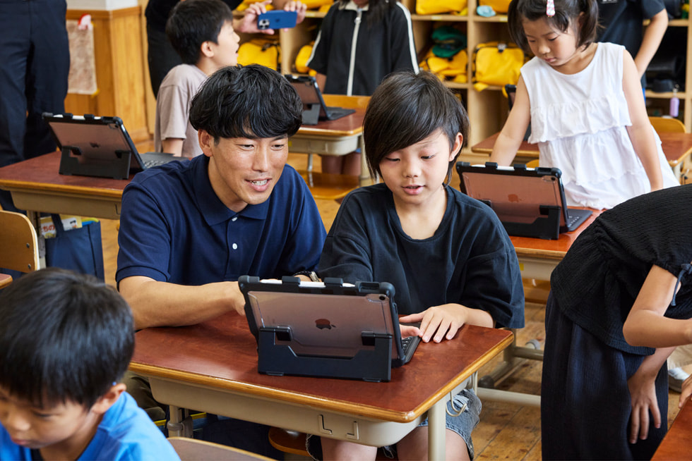 京都市の小學(xué)校の教室で、iPadで作業(yè)している子どもをサポートする教師。