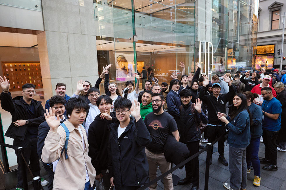 A large group of excited customers stand in line outside the Apple Sydney store in Sydney, Australia.