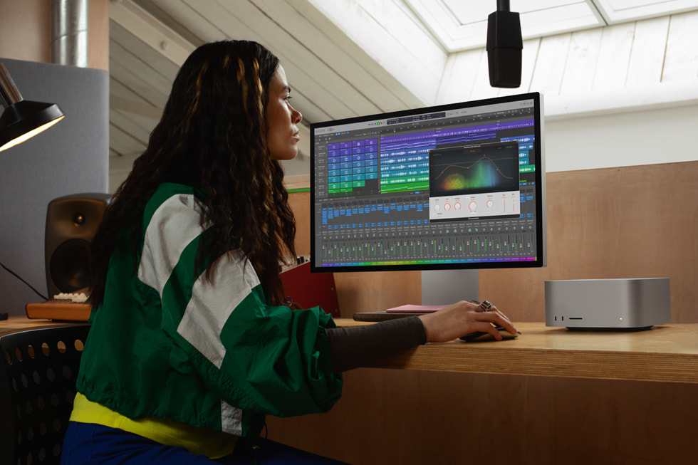 An Apple user working with M2 Ultra on Mac Studio is shown from the side.