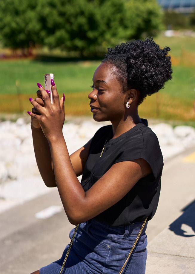 Adetokunbo?Opeifa brandit son iPhone pour prendre une photo dans un parc.