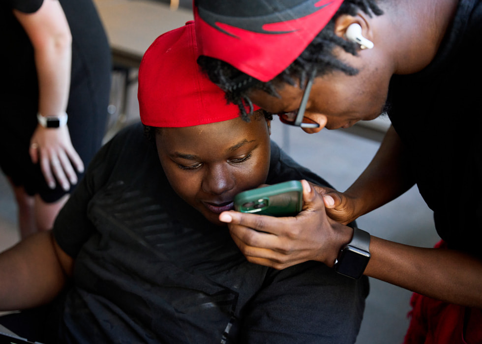 Glen-David Hardy-Covington et John?Johnson regardent l’écran d’un iPhone.