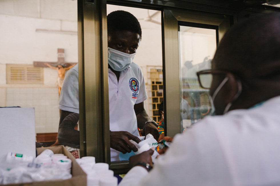 Joseph, voluntario del programa Modelo de Esperanza, recogiendo los medicamentos de la terapia antirretroviral.