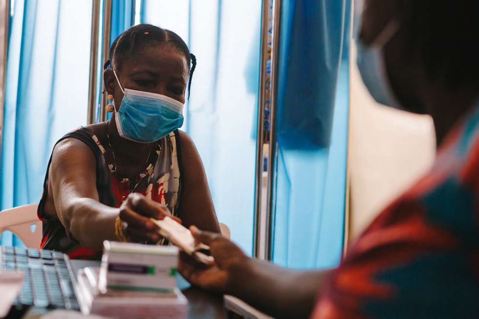 Una paciente recibiendo su medicamento de terapia antirretroviral en el Hospital St. Martin de Porres.