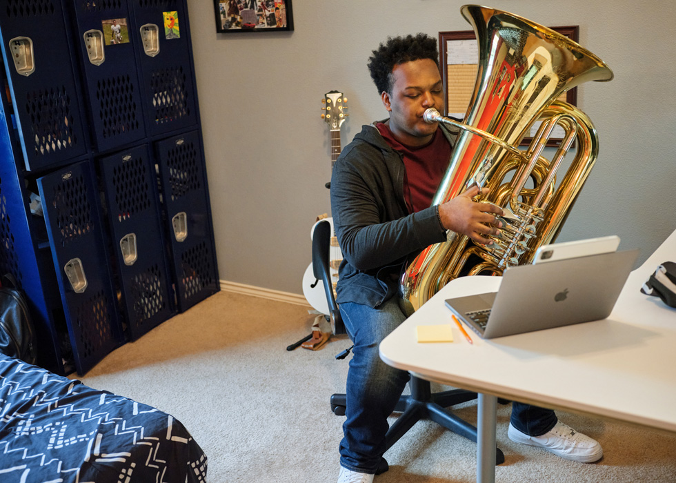 Rhys Richard toca la tuba con el iPad Pro y la MacBook Pro.