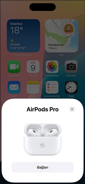 MagSafe ?arj Kutusu'nun i?indeki AirPods Pro'nun iPhone'un yan?nda g?rünümü. G?rselde iPhone'un Ana Ekran'?nda bir pencere g?steriliyor, penceredeki ba?lan dü?mesine bas?ld???nda AirPods'la kolayca e?le?iyor.