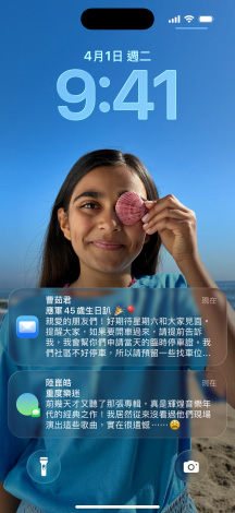 五款層疊的 iPhone 機(jī)型微微展開，每款機(jī)型彼此略微重疊。最左側(cè)的螢?zāi)徽故居嵪?app 中設(shè)有背景的對(duì)話；左側(cè)第二個(gè)螢?zāi)徽故局鳟嬅?，其中包含色彩繽紛的 app 圖像；中間的機(jī)型展示鎖定畫面，其中包含照片、呈現(xiàn)時(shí)間的 Liquid Glass 數(shù)字設(shè)計(jì)，以及兩則顯示在螢?zāi)坏撞康耐ㄖ?；右?cè)第二款機(jī)型展示 Liquid Glass 設(shè)計(jì)的透明 app 圖像；最右側(cè)的機(jī)型展示 Liquid Glass 設(shè)計(jì)下的音樂播放器