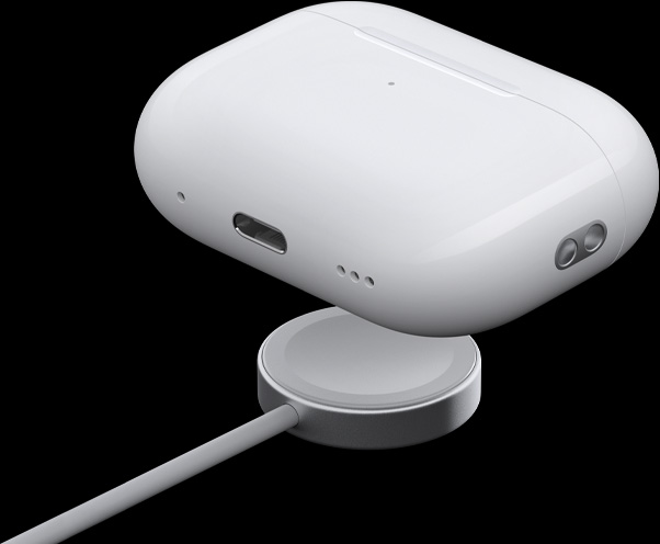 Vue de trois quarts du bo?tier de charge MagSafe mettant en évidence le haut-parleur, la boucle pour dragonne et le port USB-C, le bo?tier surplombe la rondelle de charge de l’Apple Watch.