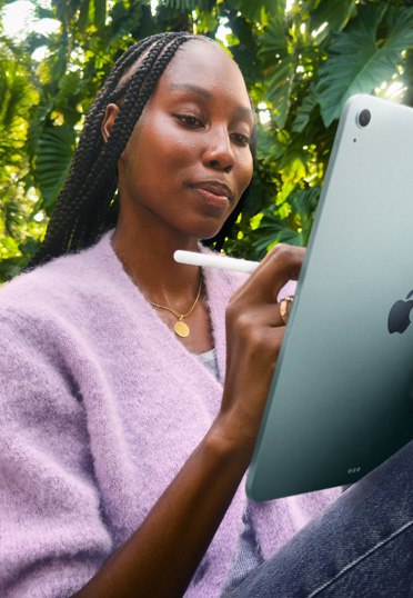 屋外で座っている學生。iPadとApple Pencil Proを持っている