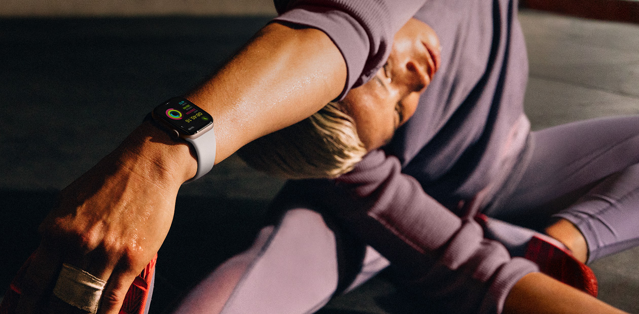 En kvinne strekker ut mens hun har p? seg en Apple Watch.