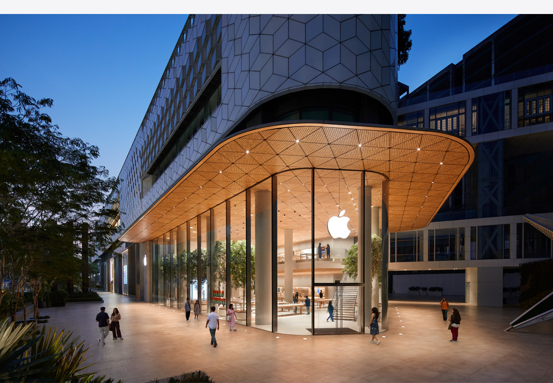 晚上的 Apple Store，展示多塊玻璃窗，室內(nèi)明亮，正門頂部有 Apple 標誌。