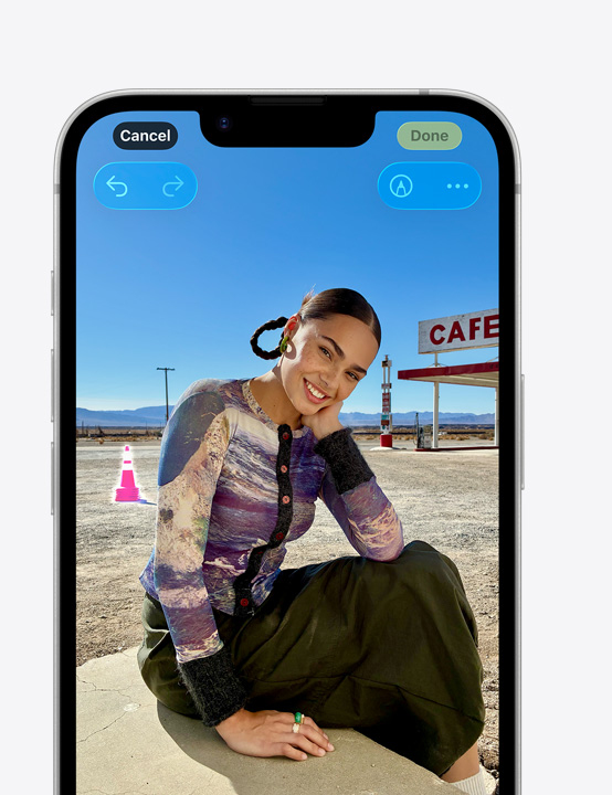 iPhone 螢?zāi)伙@示一個人在沙灘上微笑的相片，展示如何使用清除工具移除背景中的錐形路標