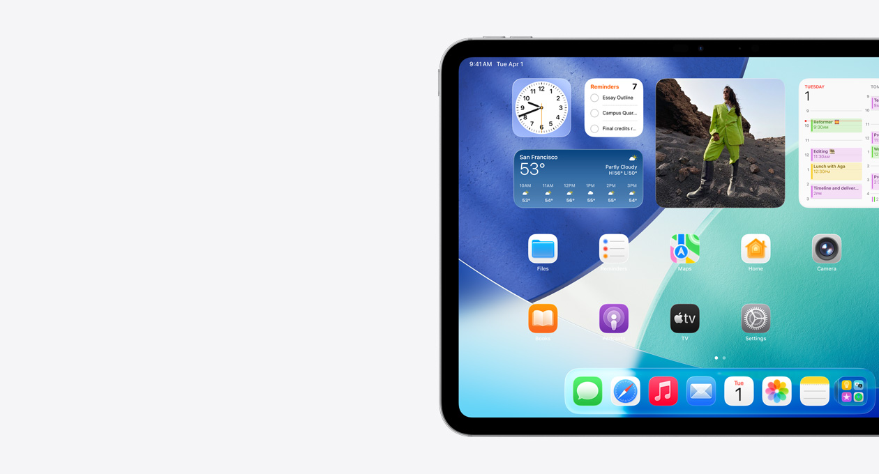iPad n?m ngang, ch? th?y phía bên trái màn hình, Màn Hình Chính v?i các ti?n ích x?p ch?ng lên nhau bao g?m ??ng h? trong m? th? hi?n hi?u ?ng Liquid Glass, ?ng d?ng Tìm, ti?n ích Th?i Ti?t, hai hàng ?ng d?ng nh? h?n và dock